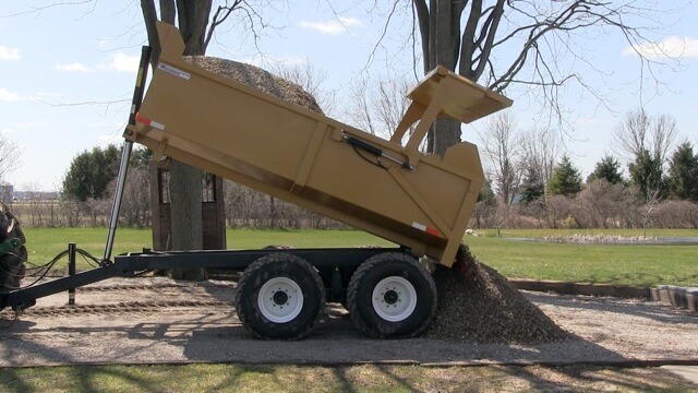 A close-up image of the 12 ton off-road dumpster trailer dumping