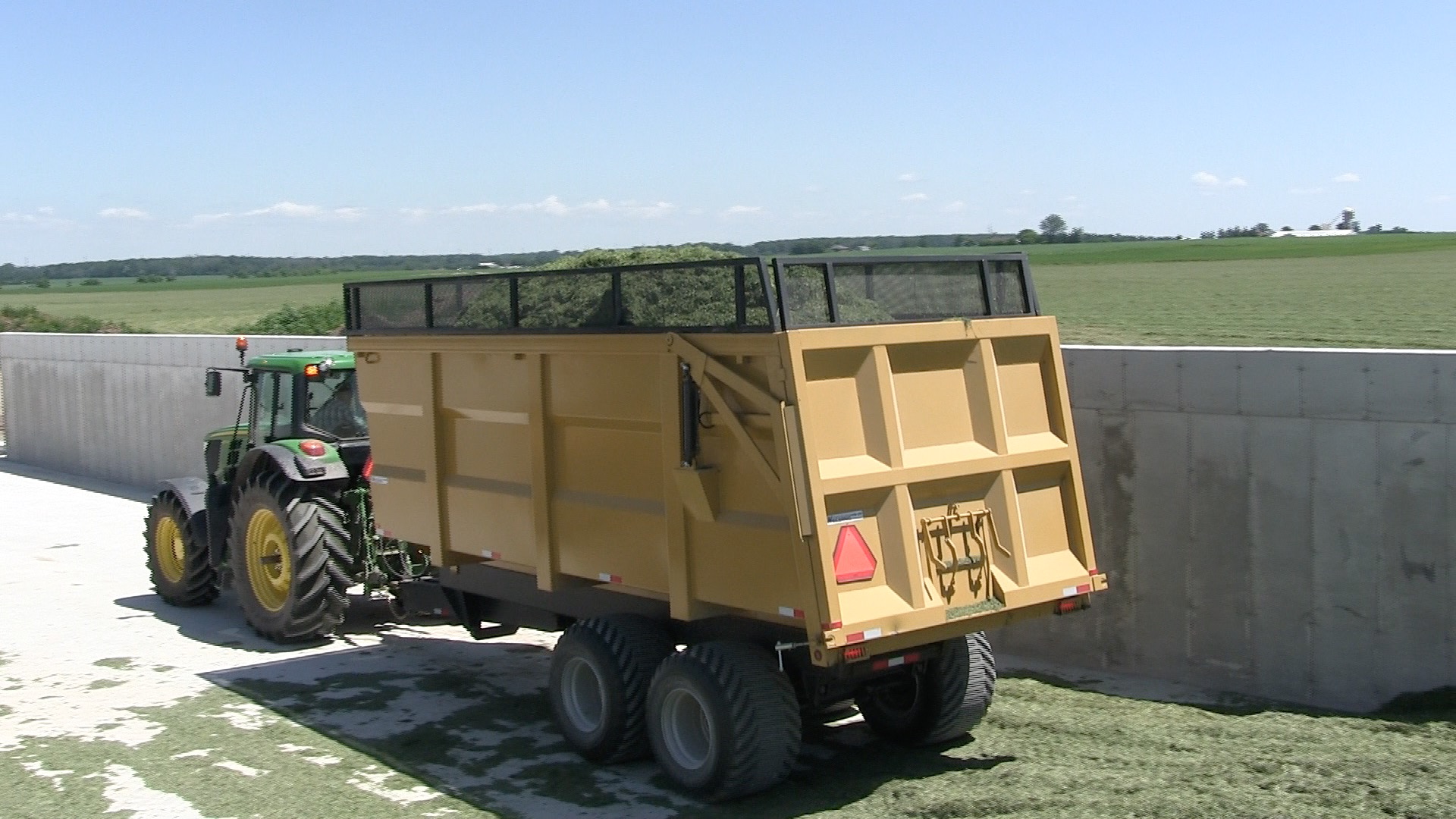 A side shot of the 20 ton silage dumper trailer dumping hay silage
