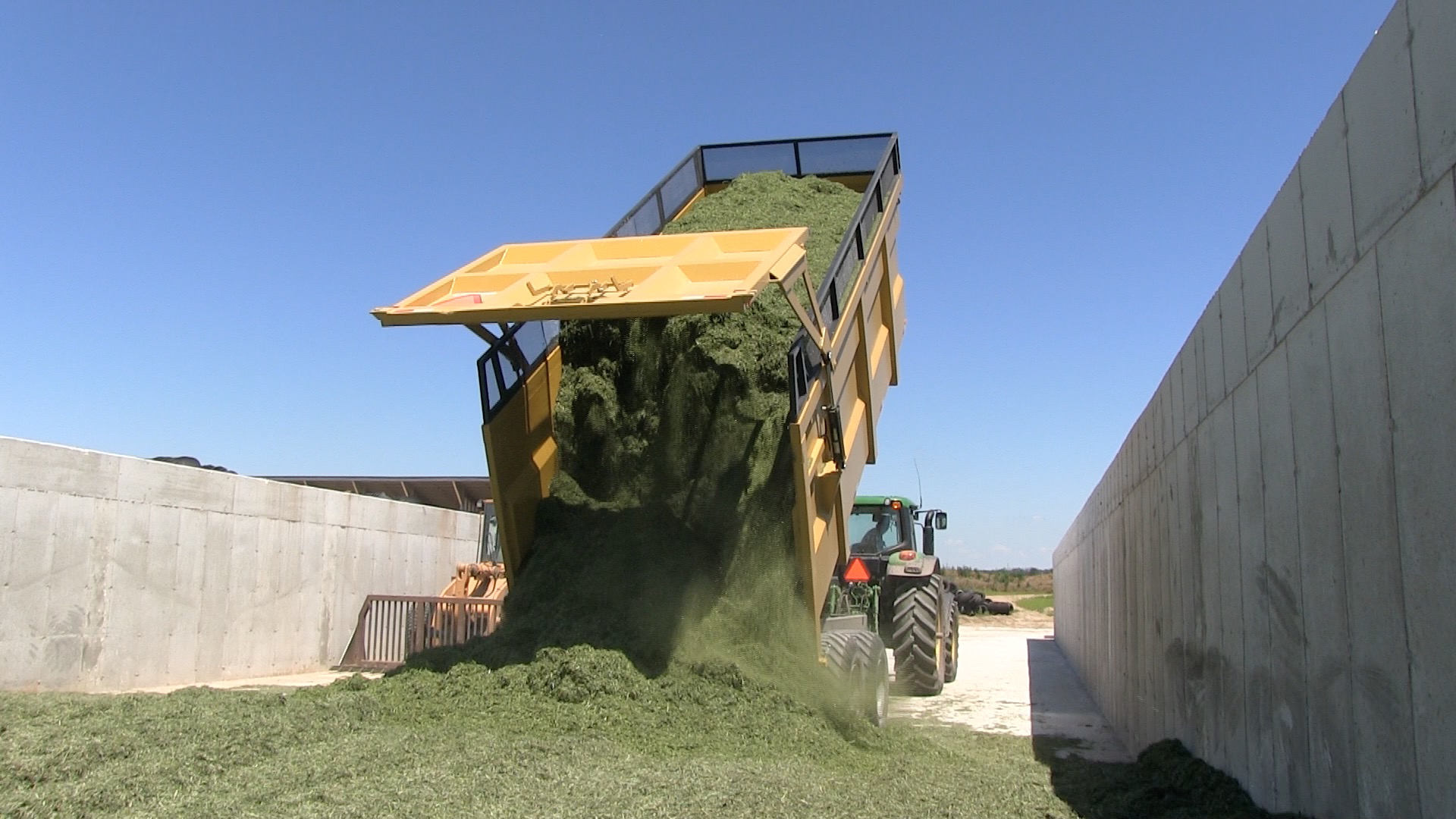 A backshot of the 20 ton silage dump trailer dumping hay silage