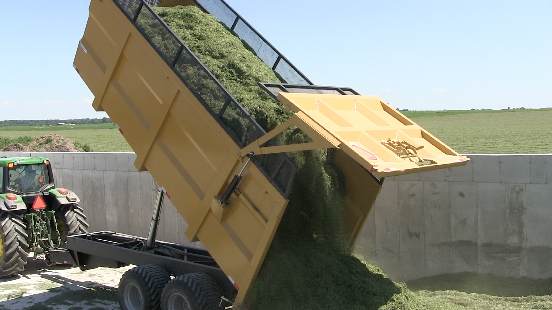 An image of the 20 ton silage dumpster trailer dumping hay silage