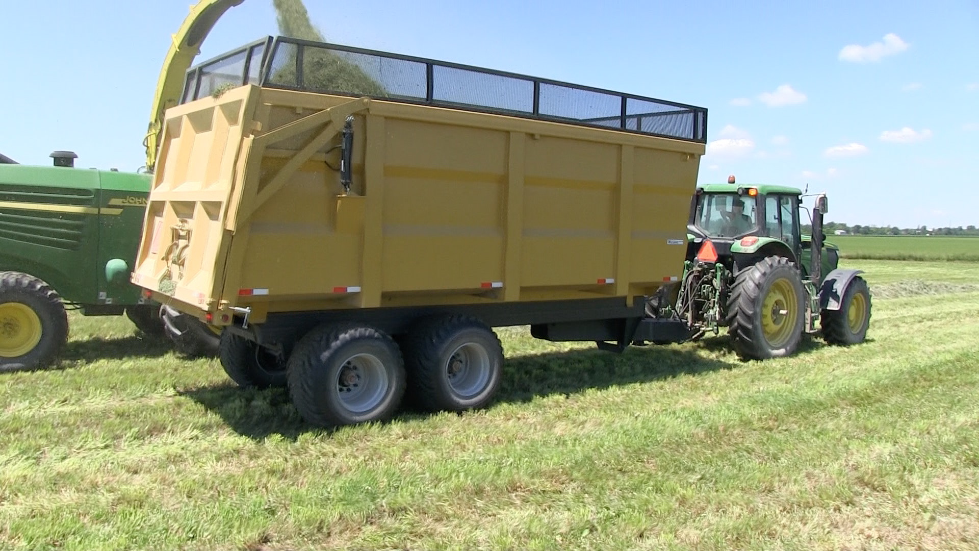A side shot of the 20 ton dump trailer getting hay silage loaded into it
