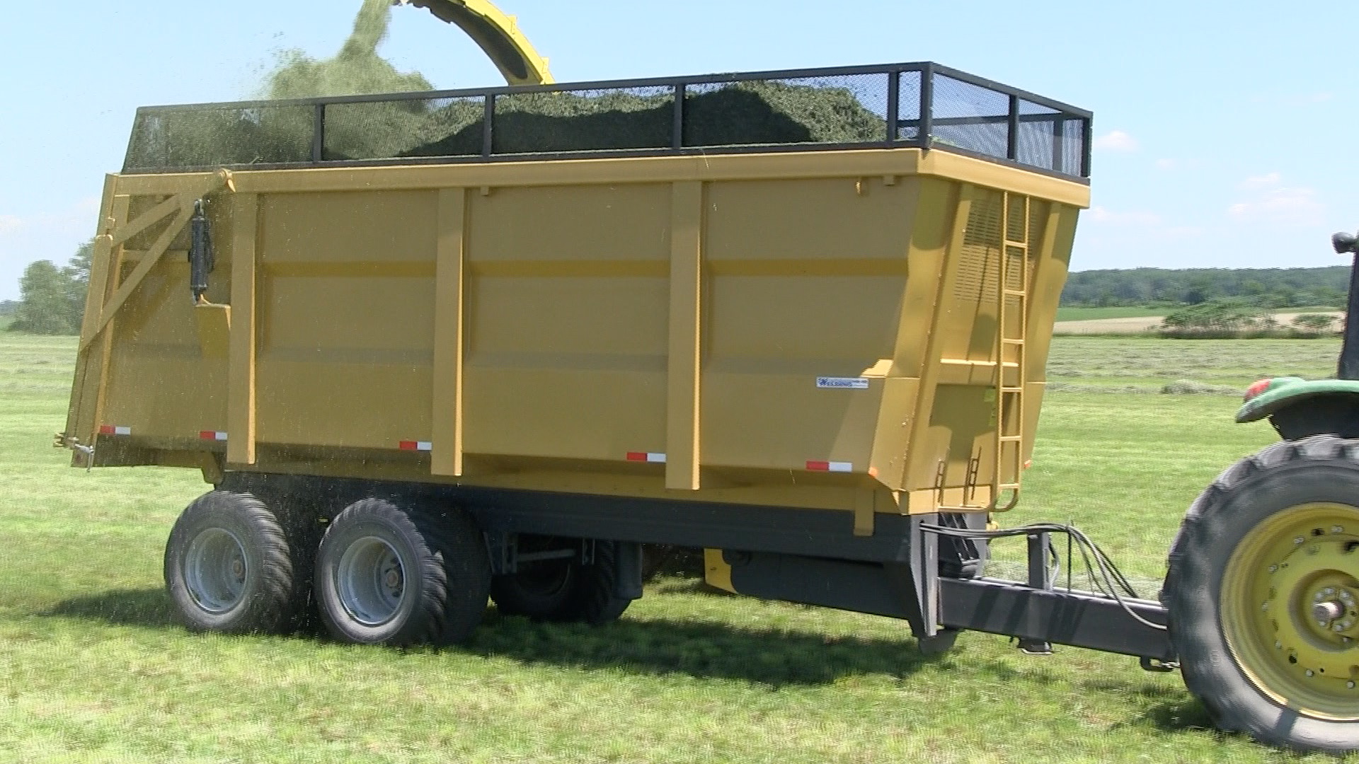 An image of the 20 ton dump trailer getting hay silage loaded into it