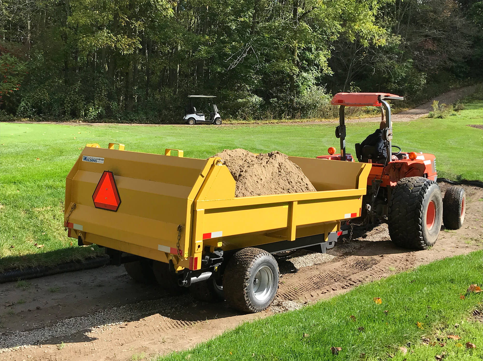 a side profile of the 5 ton turf dumper trailer hauling dirt